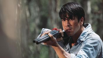 Death Whisperer 2 movie: Indonesian man in blue shirt right holds up shotgun while in forest