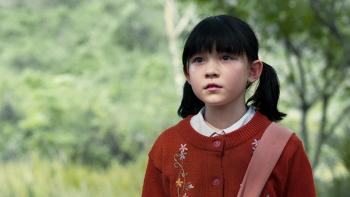 Death Whisperer movie: Thai girl in red shirt and ponytails center right stands in forest