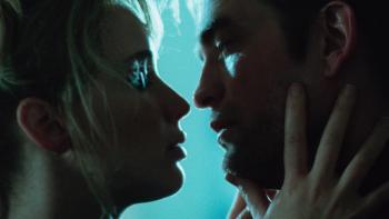 Die My Love movie: Close up of shadows of Jennifer Lawrence and Robert Pattinson's faces in profile, about to kiss, against a blue background