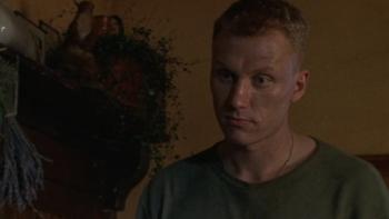Dog Soldiers: Kevin McKidd stands indoors wearing a green shirt with a plant behind him above a fireplace