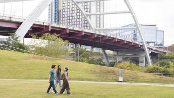 Dot Conner: Webtective movie: Gili Gould, Lauryn McCardell, and Ethan Pogue walk beside a bridge and city buildings