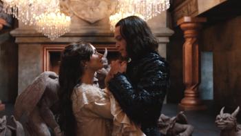 Dracula: Zoë Bleu and Caleb Landry Jones hold hands and look into each other's eyes in an elaborately decorated room