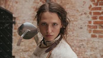 Ehrengard: The Art of Seduction movie: A Danish white woman in fencing gear looks at camera with fencing foil pointed in same direction