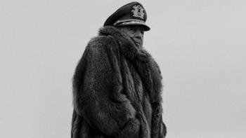El Conde movie: A Chilean military general in fur coat and military hat center stands outside