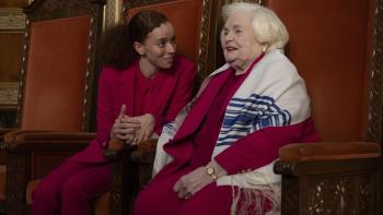 Eleanor the Great movie: Erin Kellyman holds June Squibb's hand with enthusiastic support while sitting in fancy chairs before a Jewish ceremony