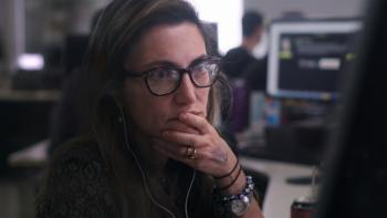 Journalist Patrícia Campos Mello looking at desktop computer screen.