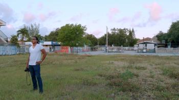 Photojournalist Carl Juste with camera on location.