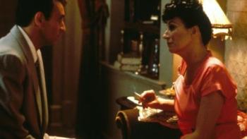 Enemies, a Love Story: A married couple argue while sitting on a bed