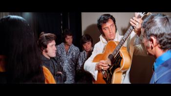 EPiC: Elvis Presley in Concert movie: Elvis Presley tunes his guitar backstage before a concert, with five band members watching