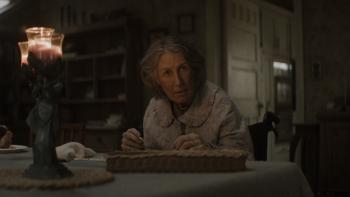 Evil Dead Burn Movie: Grandma Polly (Maude Davey) looks up from her seat at the table, a strange candle burning nearby