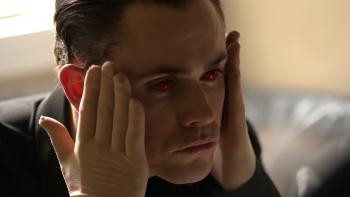 Faces of Death Movie: Killer Arthur (Dacre Montgomery) wears red contact lenses and touches his face with gloved hands