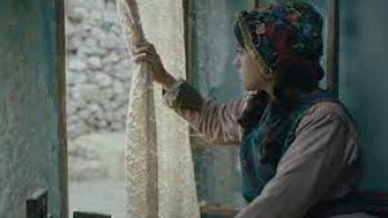 Farha: a girl peers out the window