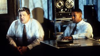 Fallen: John Goodman and Denzel Washington sit together at a desk in a police station