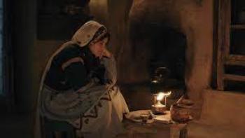 Farha: A girl sits in a dark cave lighted by kerosene lamp