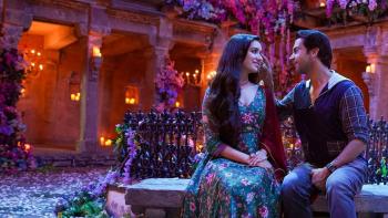 Stree 2: A romantic scene featuring a couple sitting close together in a beautifully lit courtyard adorned with flowers and candles