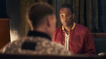 Femme: Nathan Stewart-Jarrett looks at George MacKay as they sit in a restaurant booth together, MacKay's back to the camera