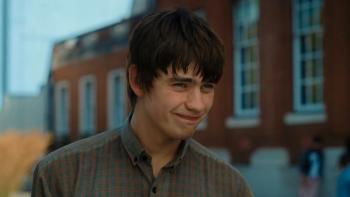 Finding Emily: A young man smiling outside a brick building