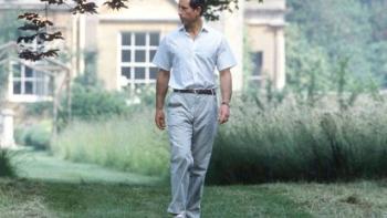 Finding Harmony—A King's Vision: A younger King Charles III wears light-colored trousers and a white shirt as he walks along a lawn