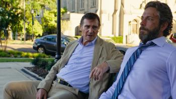 The Fix Movie: Dressed for business, Larry speaks to an angry-looking Tucker on a park bench