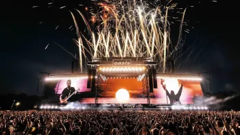 Oasis—Don't Look Back in Anger: Oasis on stage with fireworks and large crowd at night