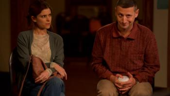 Friendship movie: Craig and Tami sit together on a couch in a suburban living room; Tami looks annoyed