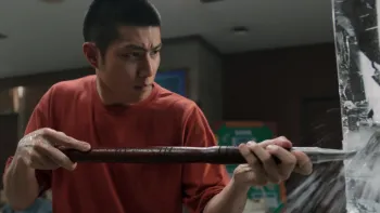 Frozen Hot Boys movie: Thai older teen boy in red t-shirt left center uses ice pick to poke at a large block of ice right