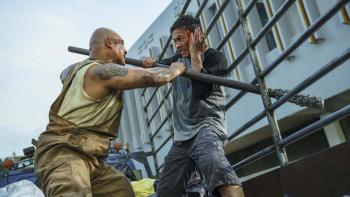The Furious Movie: A massive attacker (Brian Le) uses a metal bar to try to catch Wang Wei (Xie Miao) off guard