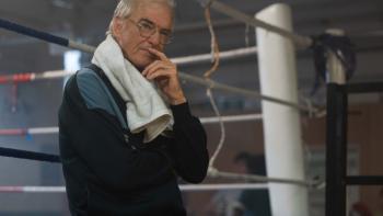 Giant: Older man with glasses and towel, standing thoughtfully by a boxing ring
