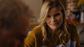 God's Country Song: An older blond woman looks with a firm look on her face in a scene from God's Country Song