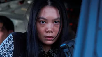 Good News movie: A Japanese woman with long black hair looks out of a plane cockpit window