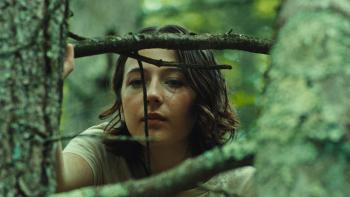 Good One Movie: In the woods, Sam (Lily Collias) peers through some branches at something