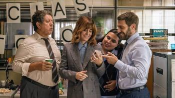 Go Team! Movie: Group of four colleagues laughing at a phone in an office.