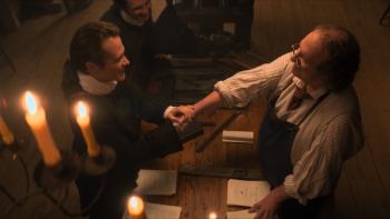 A Great Awakening Movie: Seen from above, George Whitefield and Ben Franklin shake hands across a desk