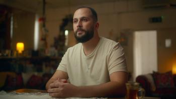 Grenfell—Uncovered: A former resident sits at a table with his hands clasped as he recalls his experience of the Grenfell Tower fire