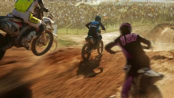 GTMax movie: Motocross bike racers race on hilly dirt path with crowd of people in background watching