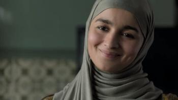 Gully Boy: Safeena, played by Alia Bhatt, stands in a living room smiling, her head and shoulders in shot.