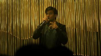 Gully Boy: Murad, played by Ranveer Singh, raps into a microphone on stage in front of a gold curtain.