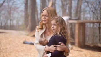 Gunslingers Movie: A worried-looking Val (Heather Graham) clutches her daughter, Grace, who holds a doll