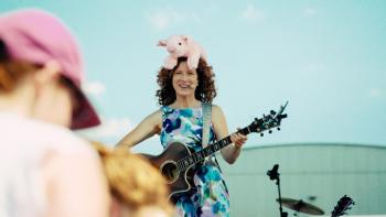 Happy and You Know It: Laurie Berkner sings with a stuffed pig on her head.