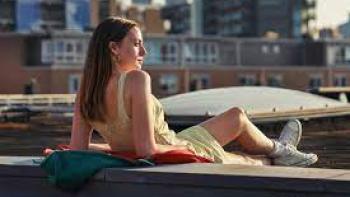 Happy Ending: A White woman lounges and look out at the city