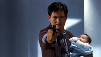 Hard Boiled: Chow Yun-Fat points a pistol while he holds a baby