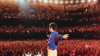 Harry Styles — One Night in Manchester: Harry Styles stands onstage with his arms stretched out to either side as he looks out into the crowd