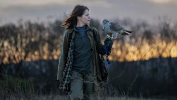 H is for Hawk: Claire Foy holds a hawk on her wrist in the middle of a field