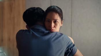 Heartbreak Motel movie: Indonesian woman center stares at camera while hugging Indonesian man in blue shirt right, back to camera