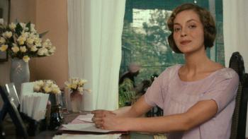 Heat and Dust: Greta Scacchi smiles as she sits at a writing desk