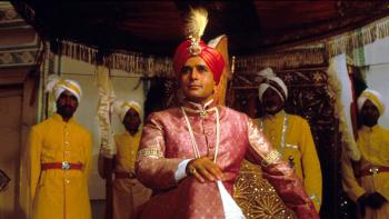 Heat and Dust: Shashi Kapoor smiles and looks forward, guards stood to attention behind him