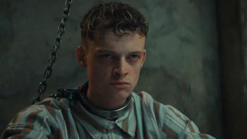 Heel: Anson Boon shackled by his neck looks angry