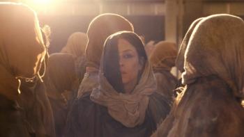 Hot Spot movie: A woman in a headscarf stands in a sunlit crowd