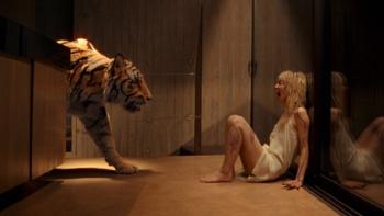 Hot Spot movie: A tiger approaches a woman sitting on the floor in a dimly lit room
