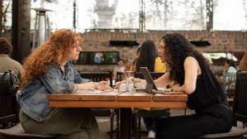 How to Deal with a Heartbreak: Two people eat and talk at a restaurant
